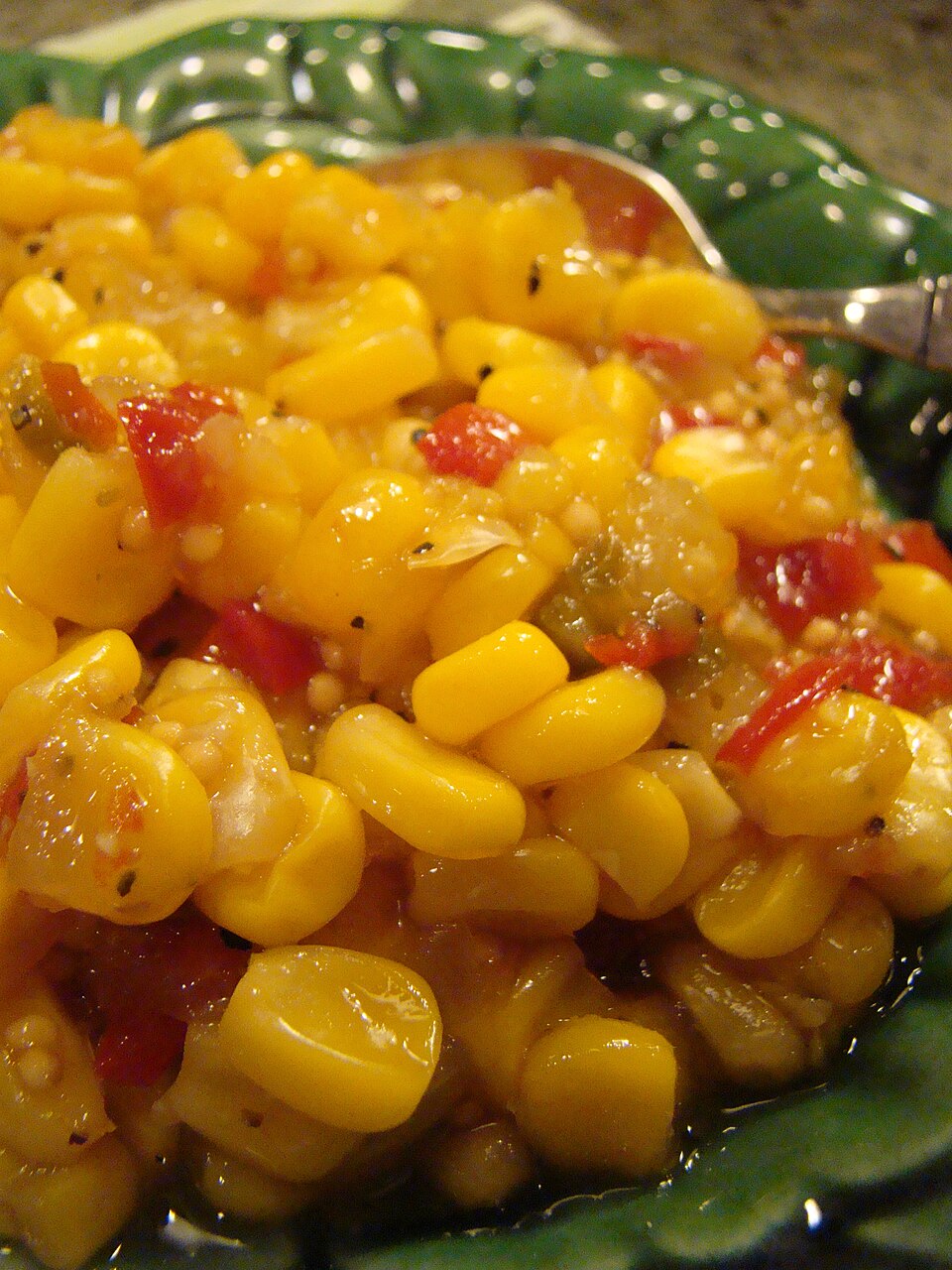 A bowl of corn relish with sweet peppers and chopped herbs