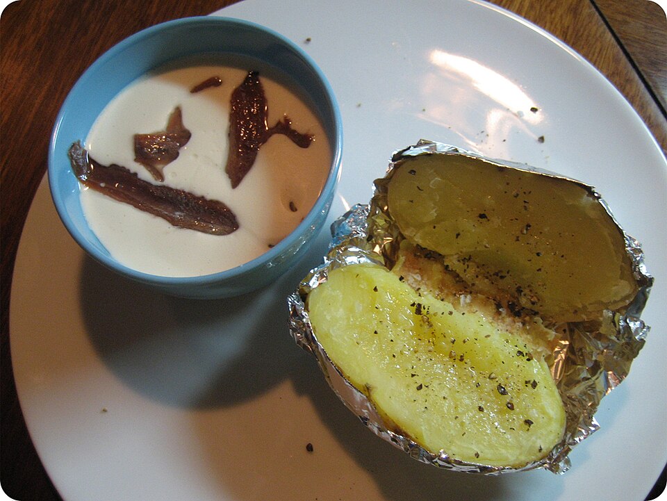 A bowl of chilled white gazpacho ajoblanco garnished with grapes and olive oil